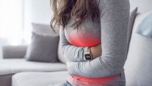 Woman experiencing IBS symptoms like bloating and stomach pain